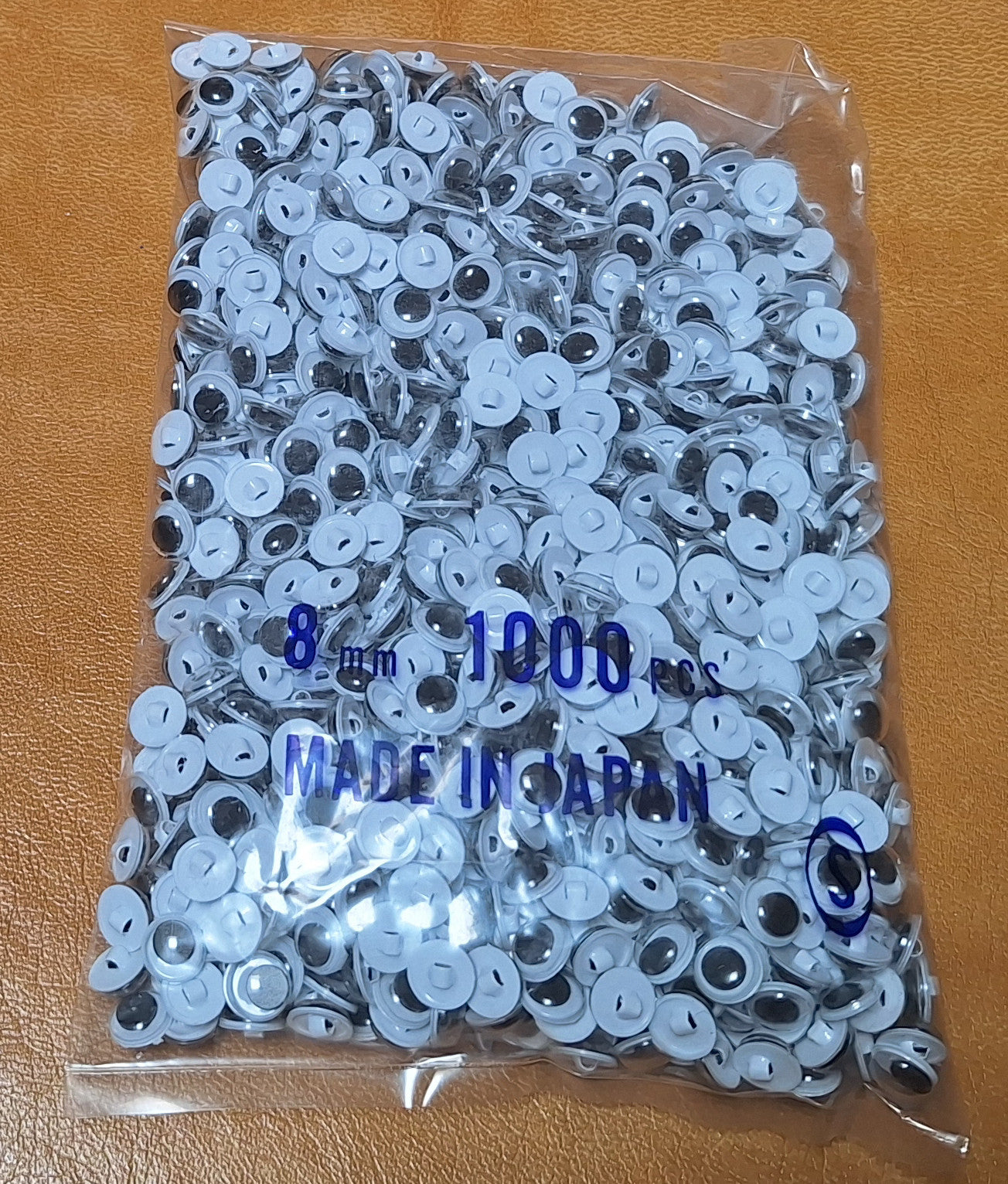 Bag of 1,000 8mm sew-on googly eyes with plastic shanks. Made in Japan.