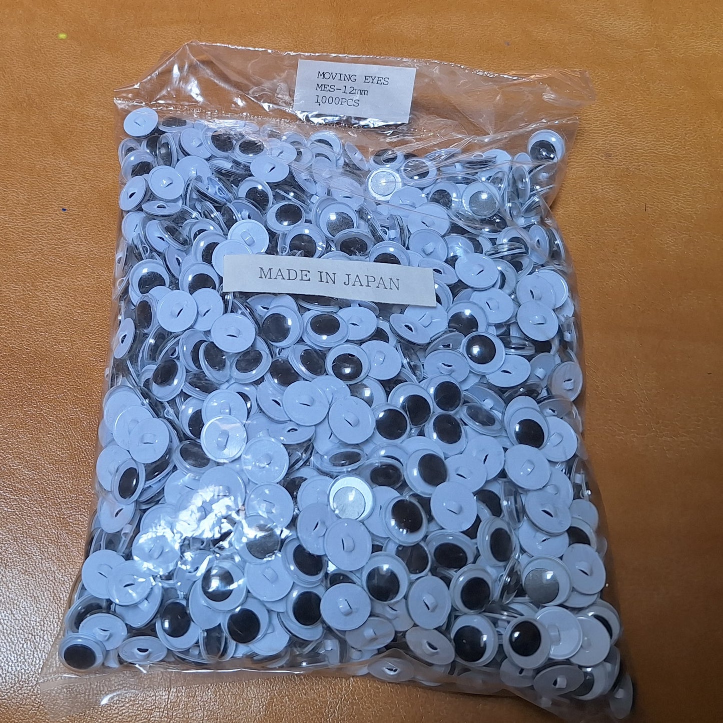 Bag of 1,000 12mm sew-on googly eyes with plastic shanks. Made in Japan.
