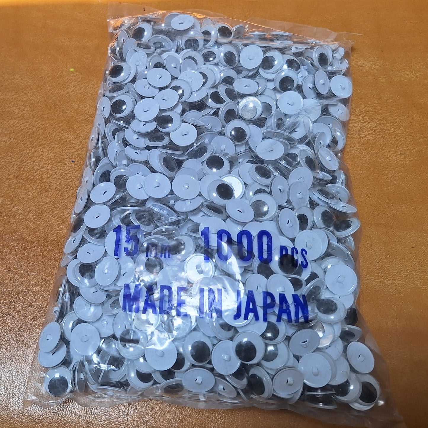 Bag of 1,000 15mm sew-on googly eyes with plastic shanks. Made in Japan.