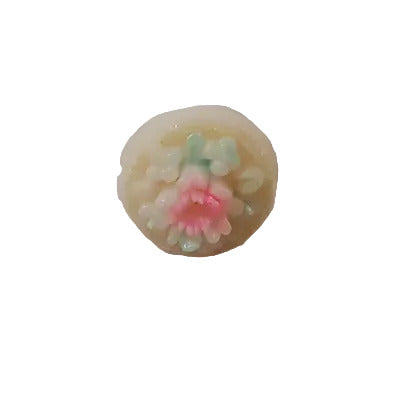 Small cream button with a raised hand-painted floral motif in pink and green, shown from the front to display the detailed design.