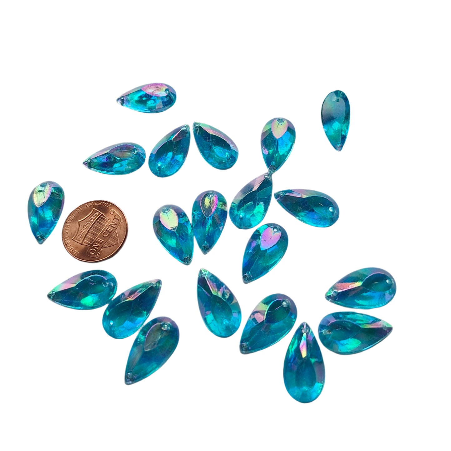 Aqua AB teardrop cabochons shown in a group, including one flipped to display the sew-on back, with a penny for scale.