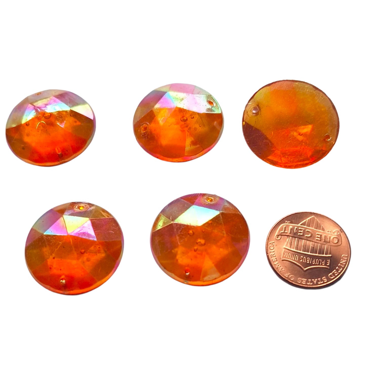 Topaz AB round faceted plastic cabochons arranged in a group of five, with one flipped to show the two-hole sew-on back; penny included for scale.