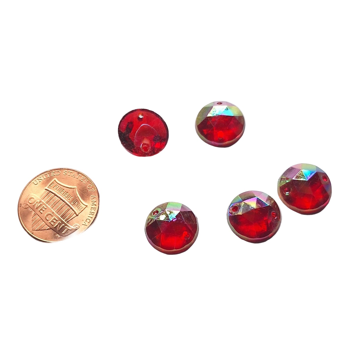 Ruby AB round faceted cabochons arranged in a group of five, with one flipped to show the two-hole sew-on back; penny included for scale.