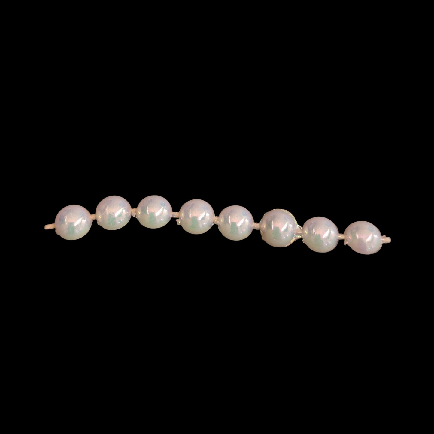 6mm plastic half-pearl trim with AB finish, molded on thread on a black background.