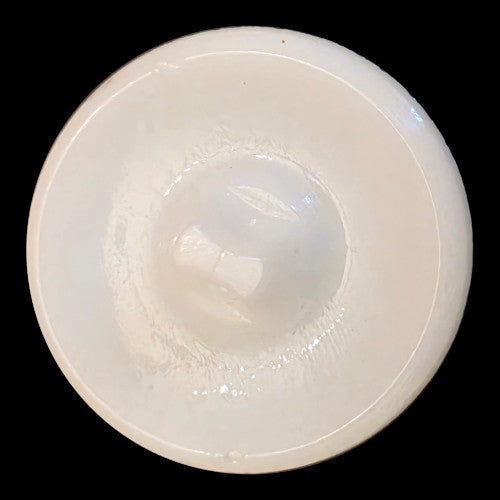 Back of white glass button with a textured geometric surface and self-shank.