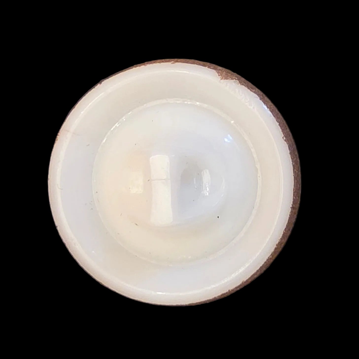 Back of white glass button with a cup-shaped form and gold-colored rim, self-shank