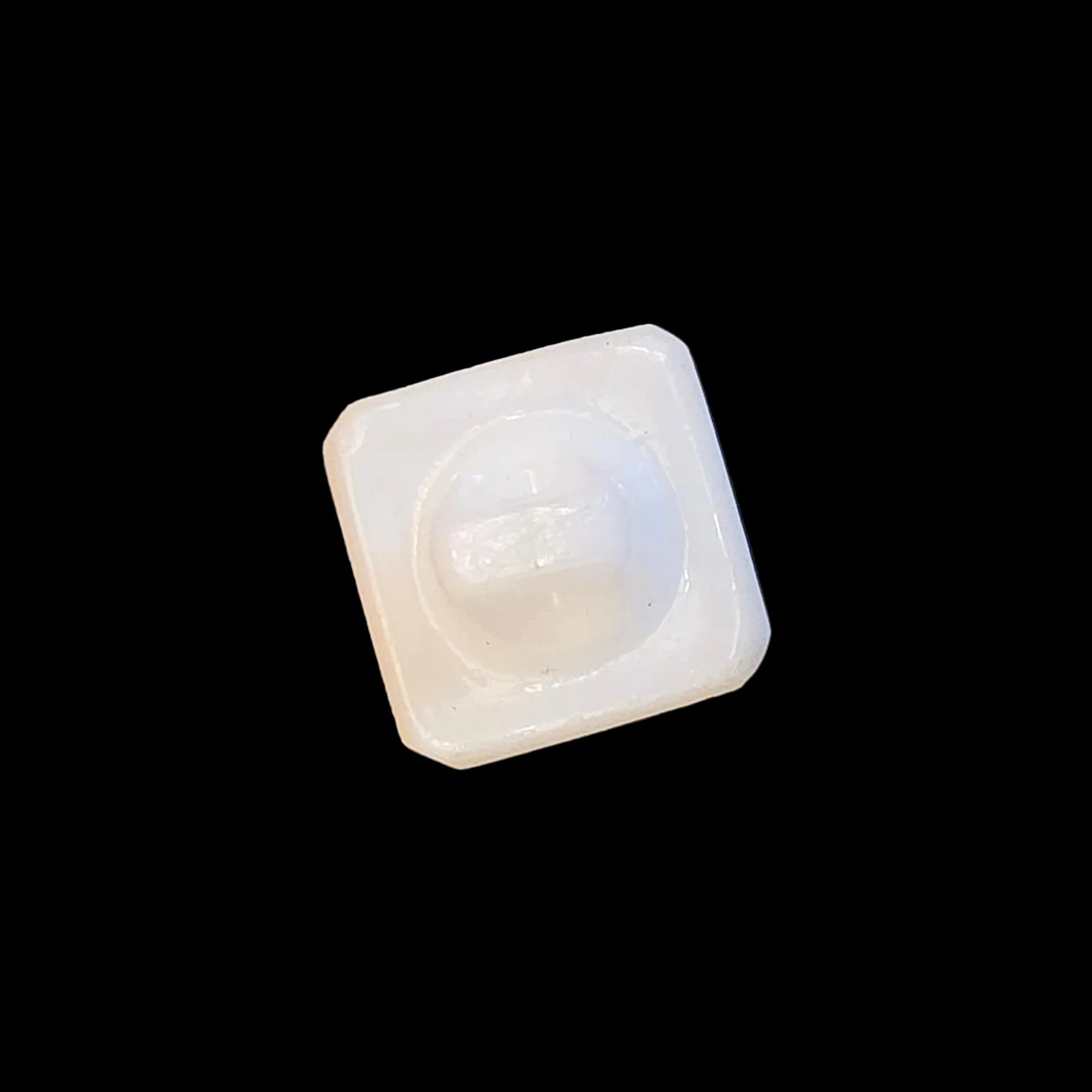 Back of white square glass button.