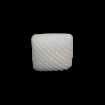 Small white square glass button with ribbed surface, photographed centered on black background.