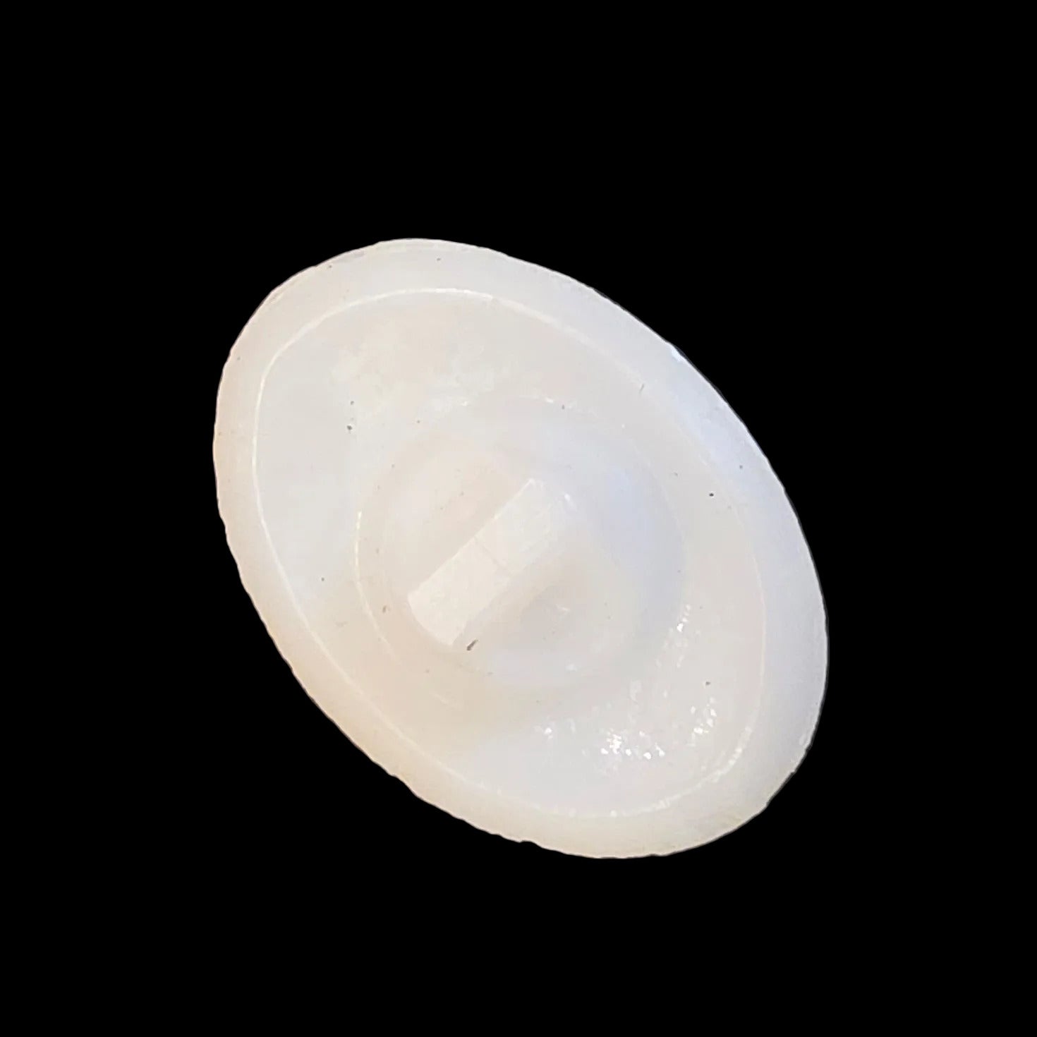 Back of white glass shank button, oval shape.