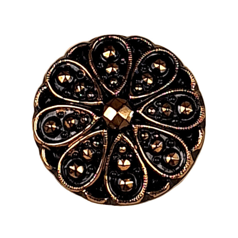Decorative button with black and gold design on a white background