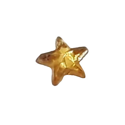 Tiny 5 mm topaz mirrored glass star cabochon shown in close-up.