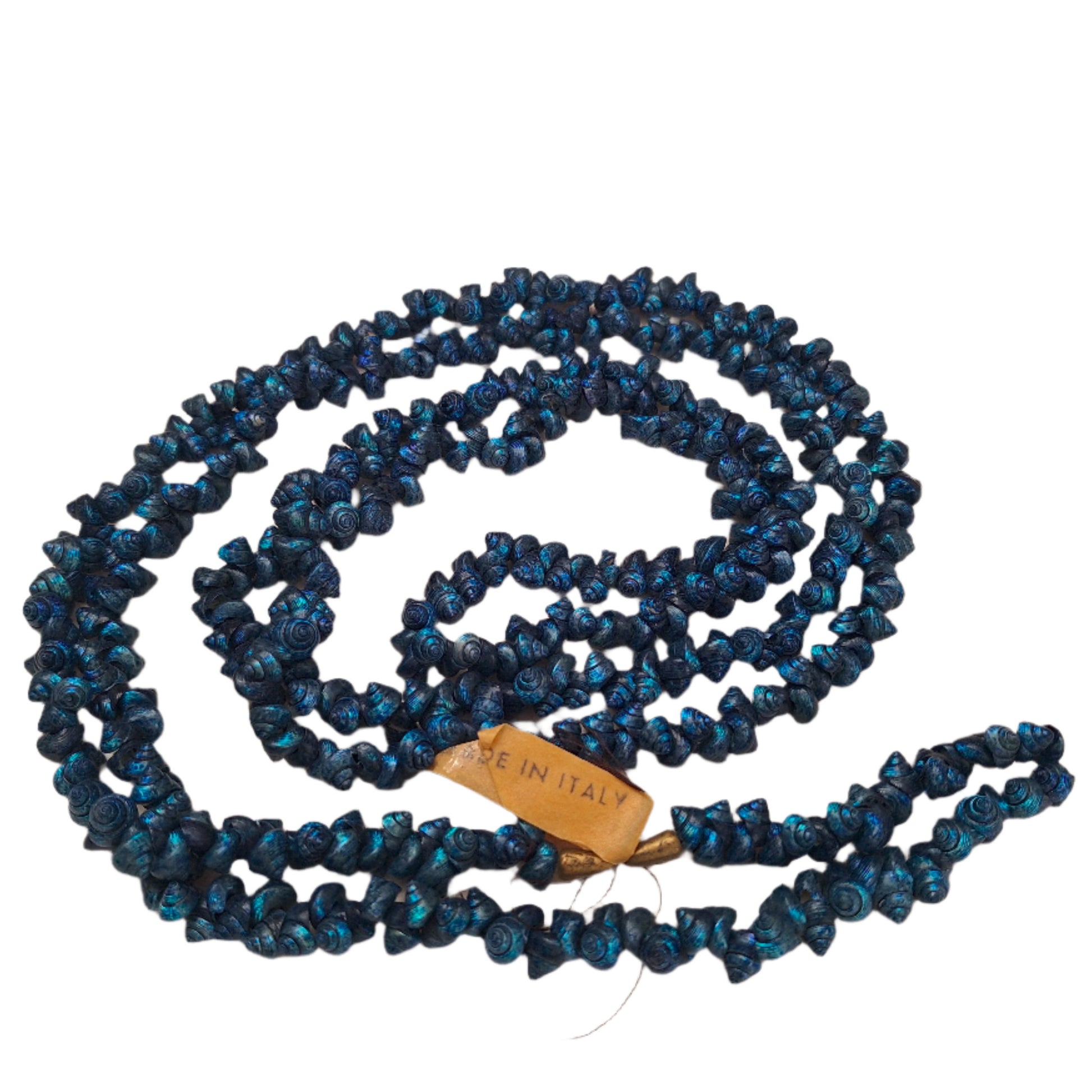 Blue strung seashells with hand-punched holes and natural 1/4-inch shells shown on complete strand with made in Italy label attached.