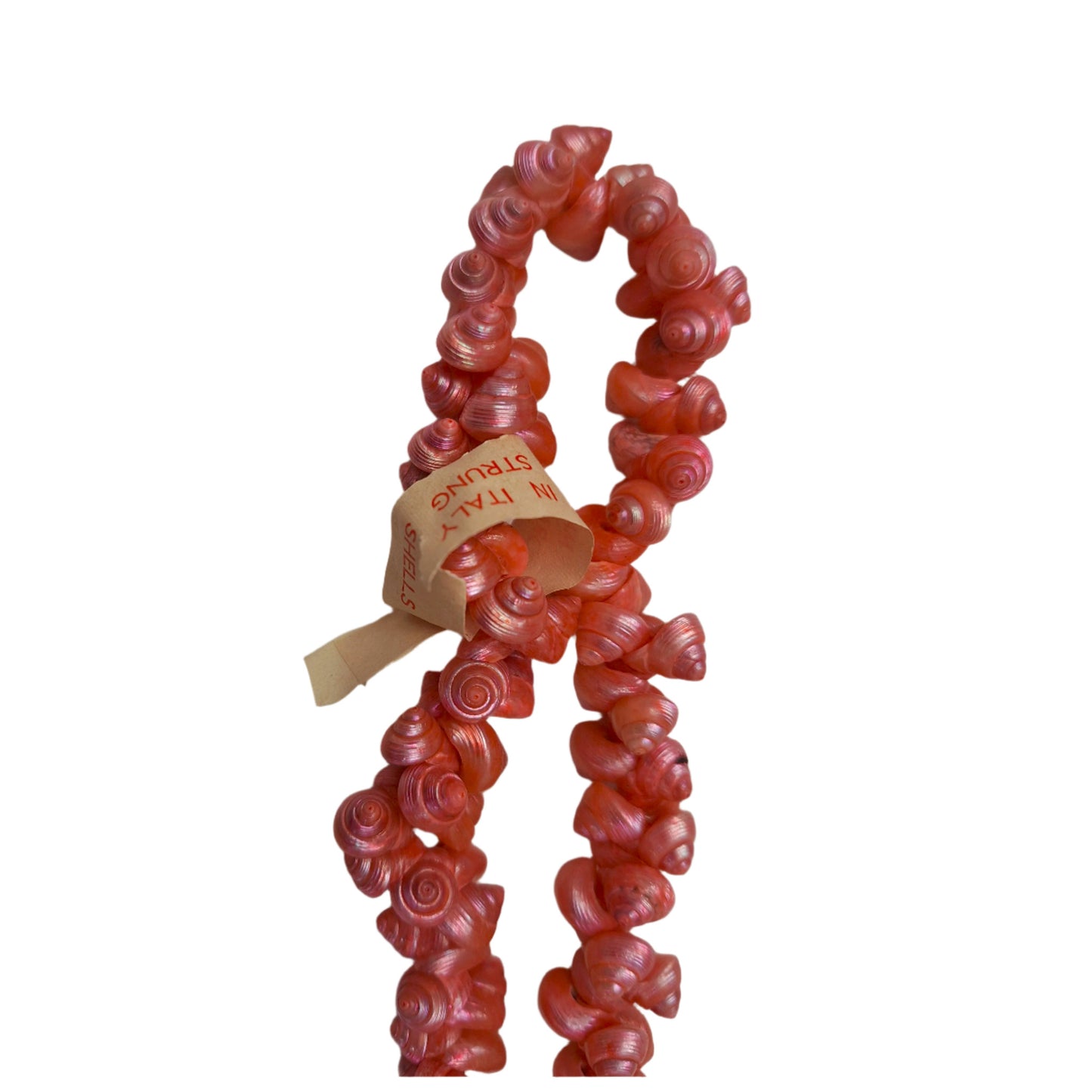 Dark pink strung seashells with hand-punched holes and natural 1/4-inch shells shown on strand segment with made in italy label attached.