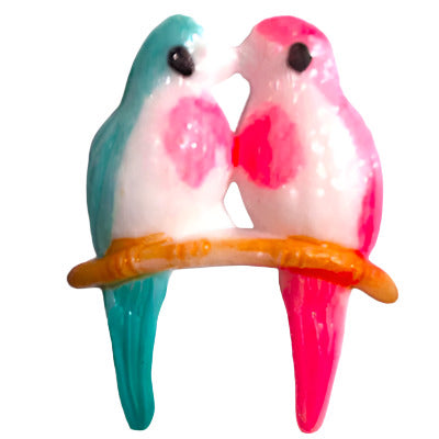 Hand-painted plastic flat back of red and green lovebirds on a brown branch