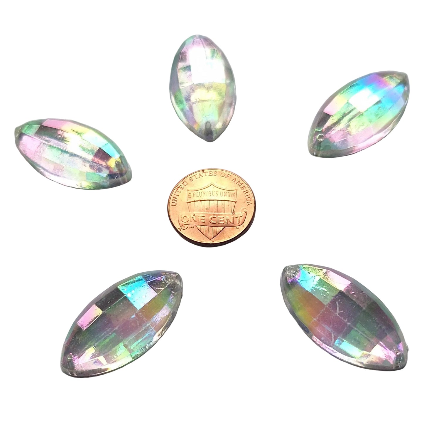 Five crystal faceted plastic navette cabochons, 30x1 5 mm, with an iridescent finish arrayed around a US Penny for scale.