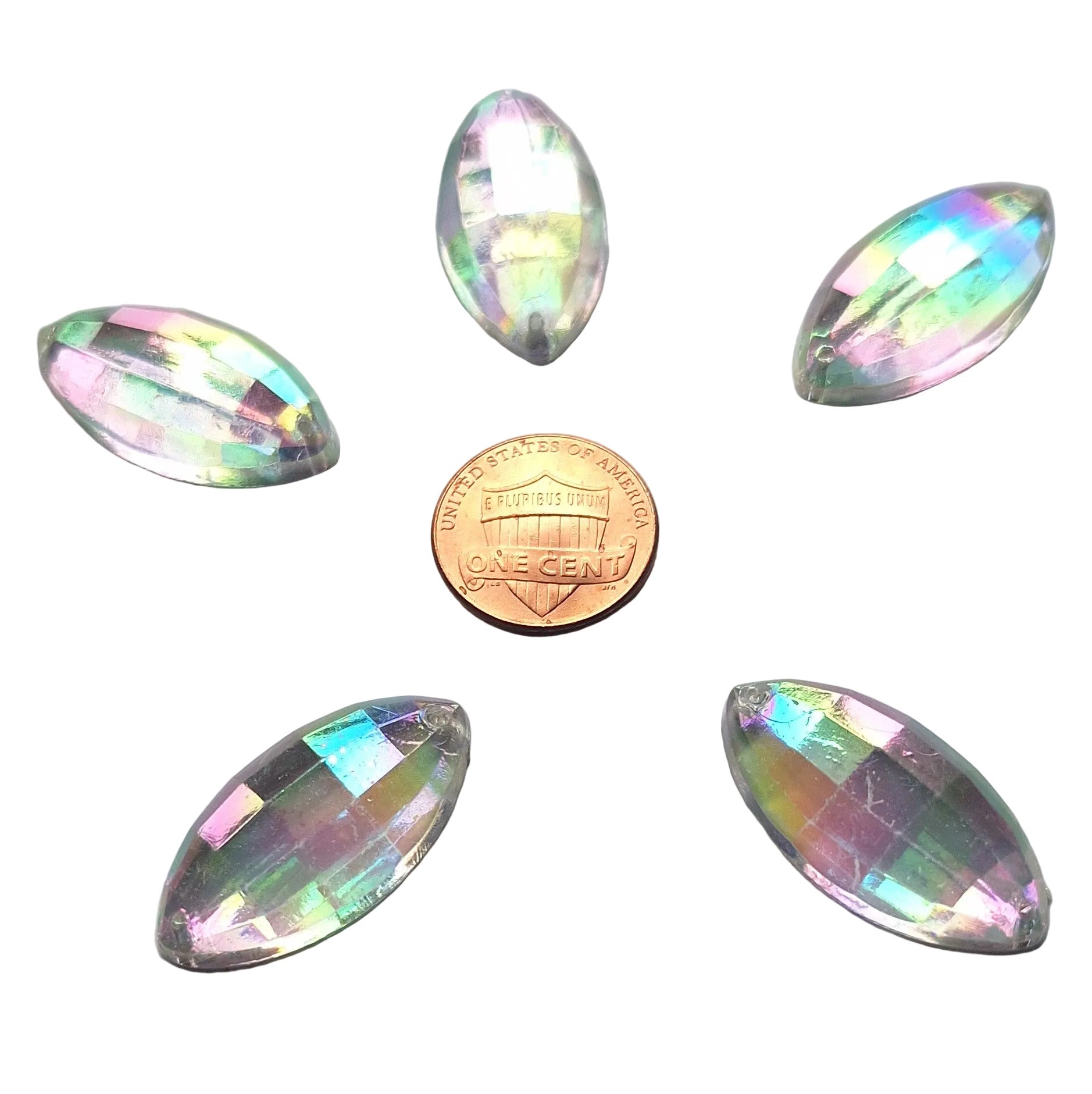 Five crystal faceted plastic navette cabochons, 30x1 5 mm, with an iridescent finish arrayed around a US Penny for scale.