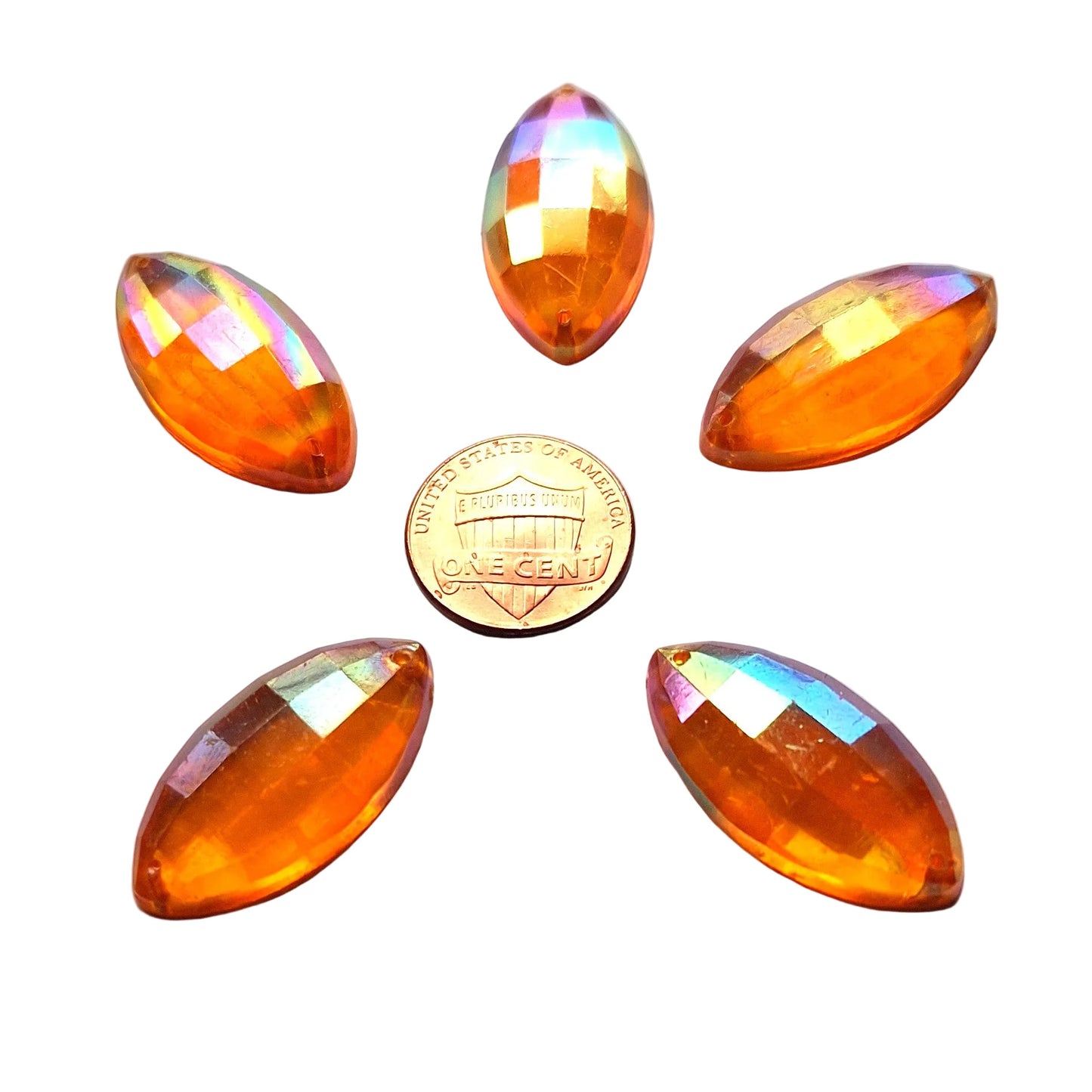 Five topaz faceted plastic navette cabochons, 30x1 5 mm, with an iridescent finish arrayed around a US Penny for scale.