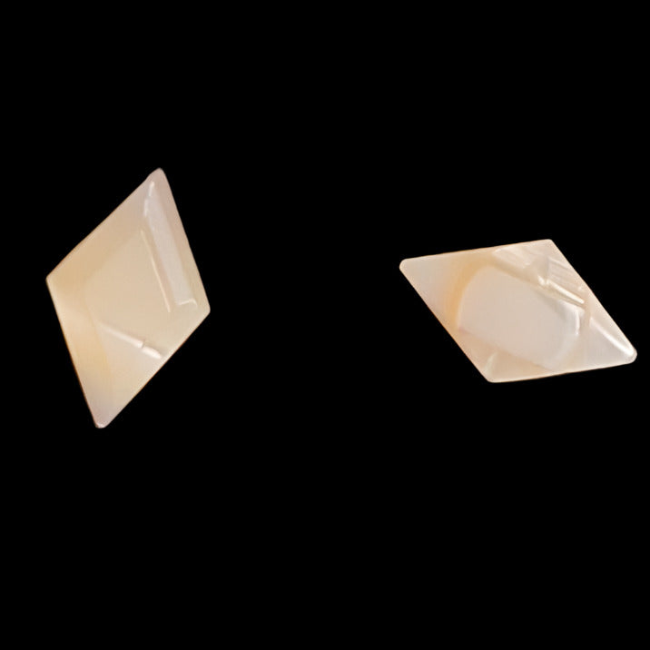 Front and back views of a diamond-shaped carved shell button, displaying the faceted front and smooth flat back on a grey background.
