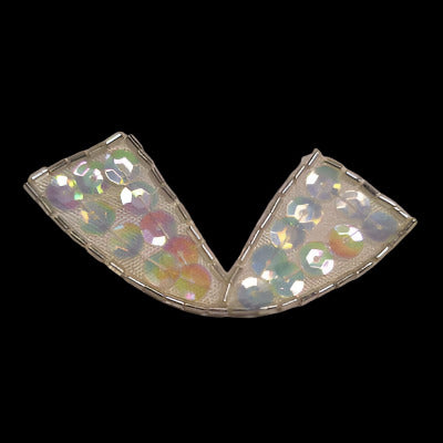 Bow-shaped applique with an outline of bugle beads and covered with iridescent sequins, on a black background