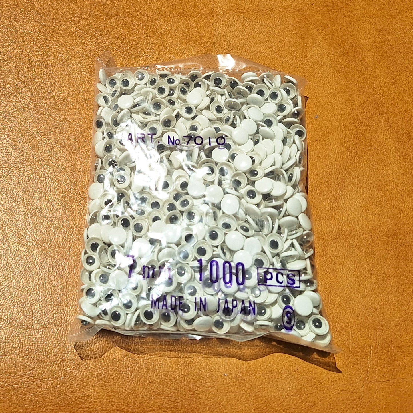 Bag of 1000 7mm paste-on googly eyes with a flat black pupil made in Japan.