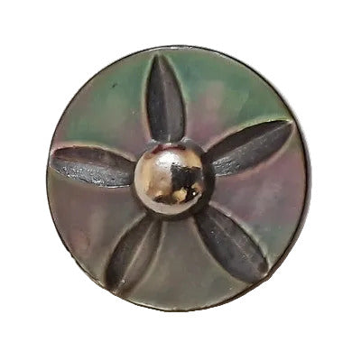 Front view of a carved shell button showing a five-point star motif cut into the iridescent surface and a round metal center, centered on a white  background.