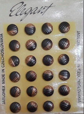 Button card of 24 22L Ribbed glass buttons with gold colored embossed flowers on one half