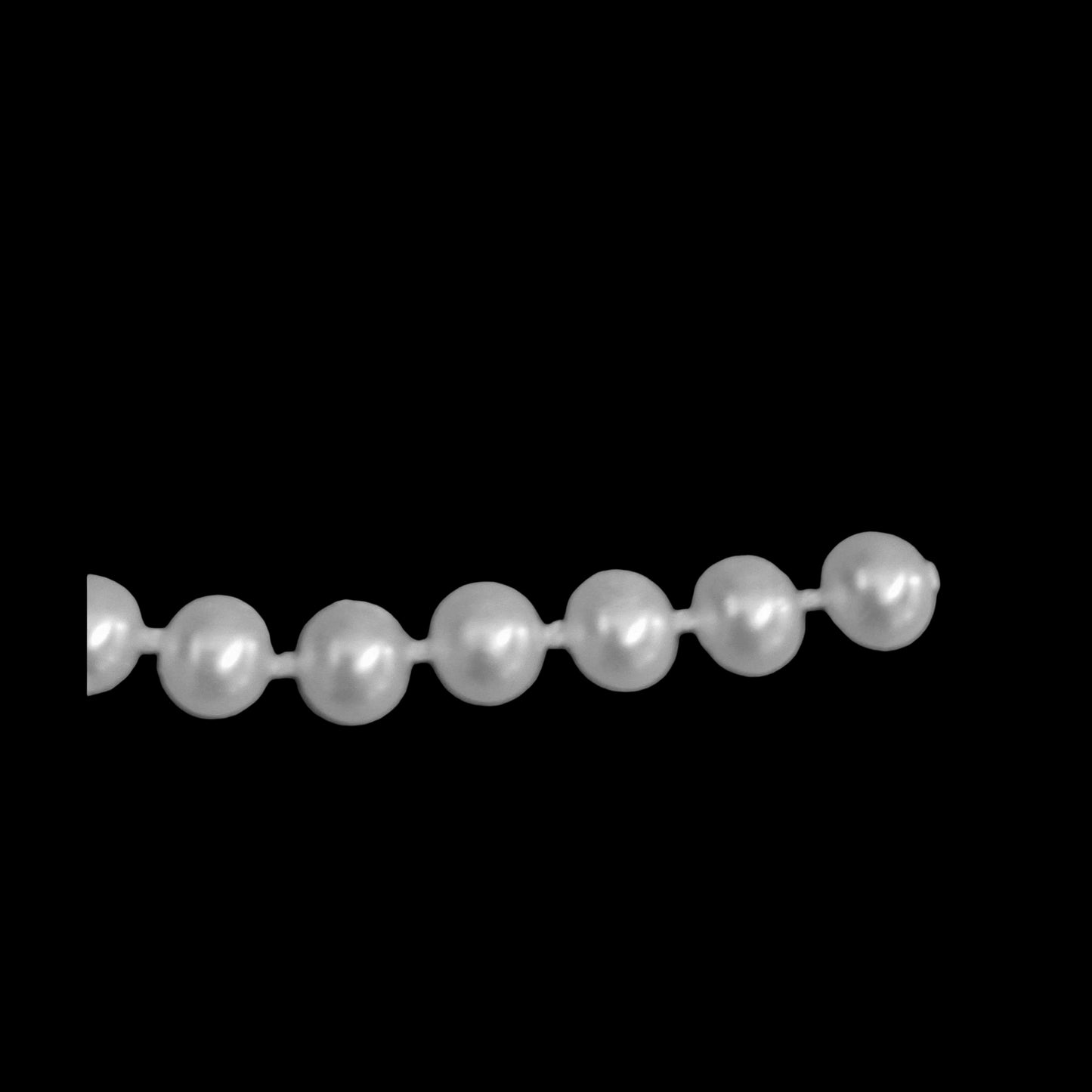 6mm plastic half-pearl trim molded on thread on a black background