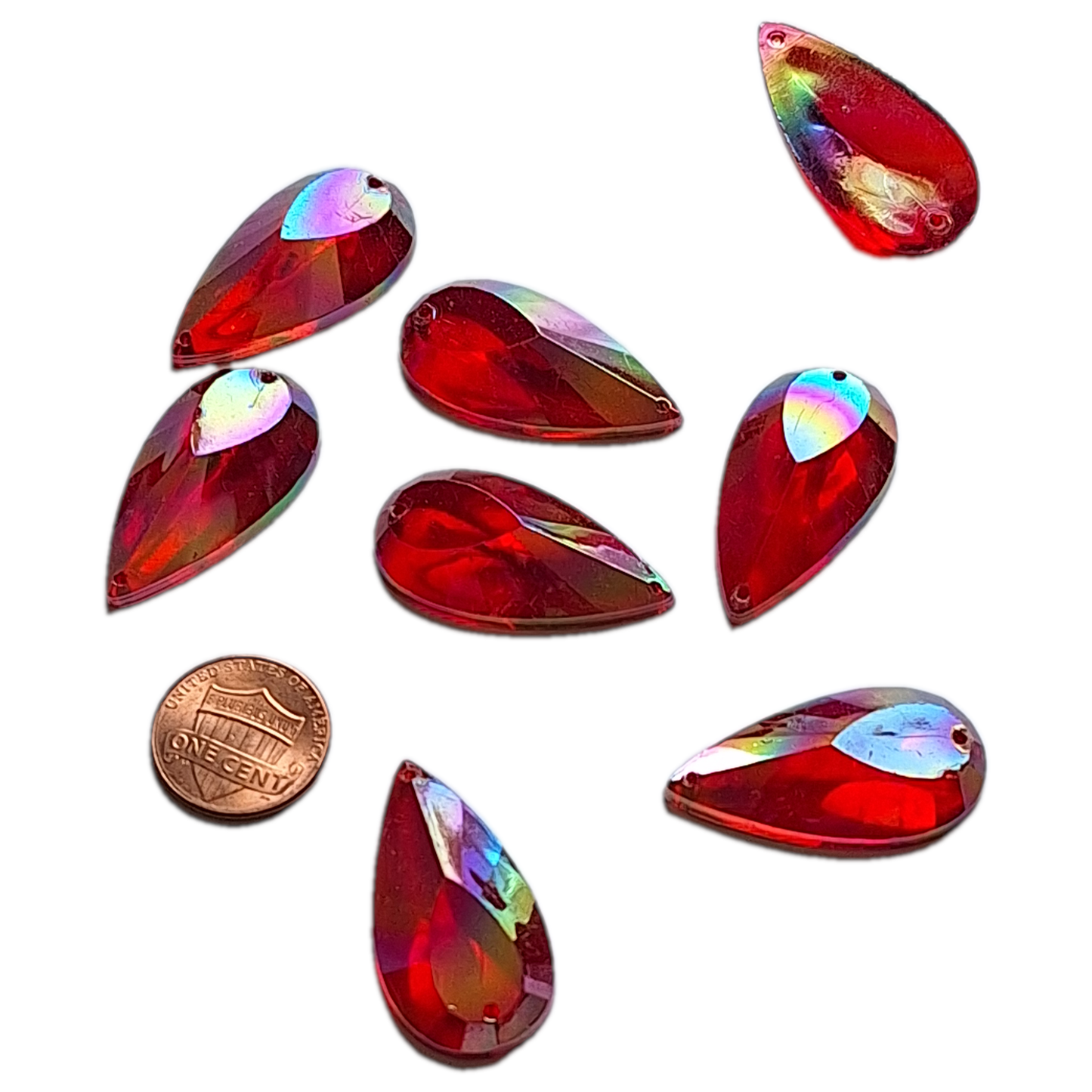 Ruby AB teardrop cabochons shown together, with a penny for scale.