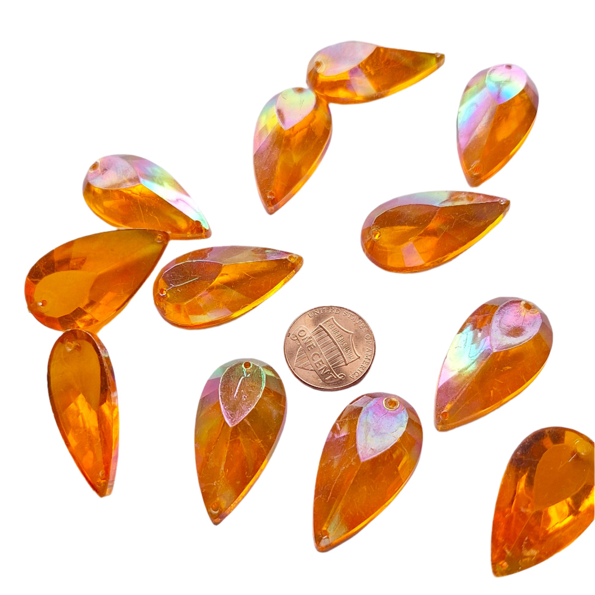 Topaz AB teardrop cabochons shown together, with a penny for scale.