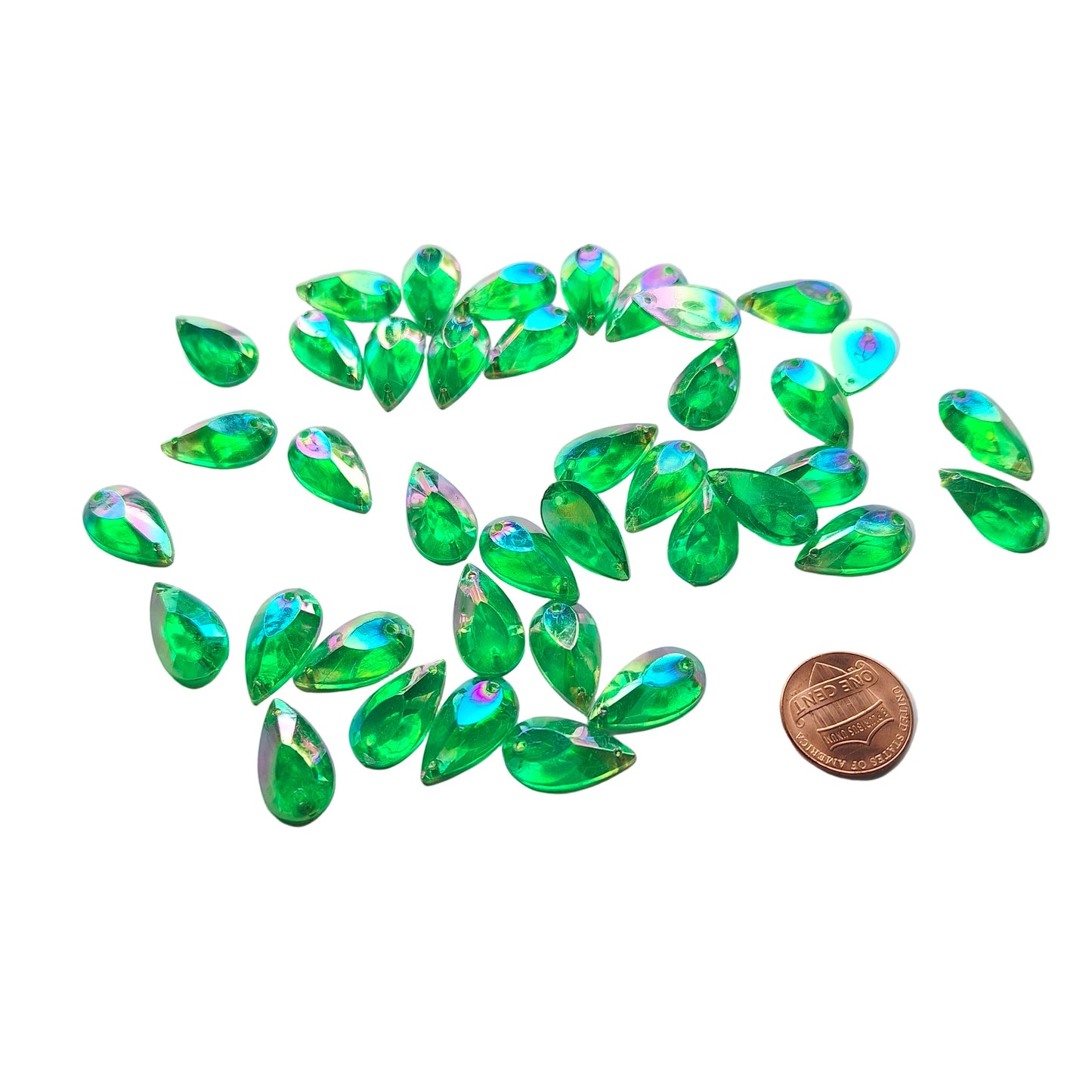 Emerald AB teardrop cabochons shown in a group, including one flipped to display the sew-on back, with a penny for scale.