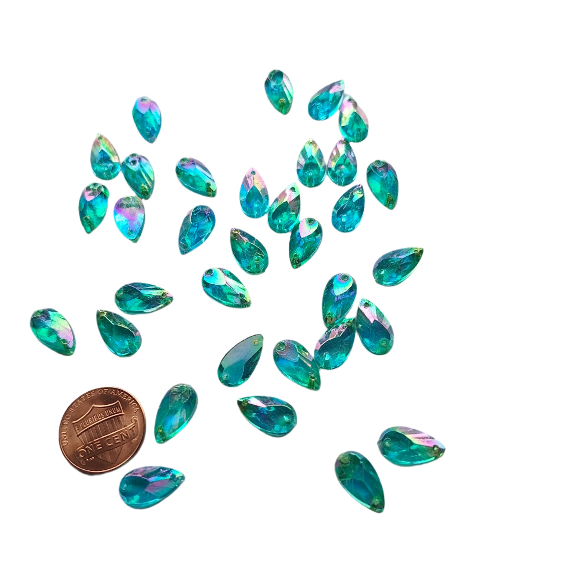Aqua AB teardrop cabochons shown in a group, including one flipped to display the sew-on back, with a penny for scale.