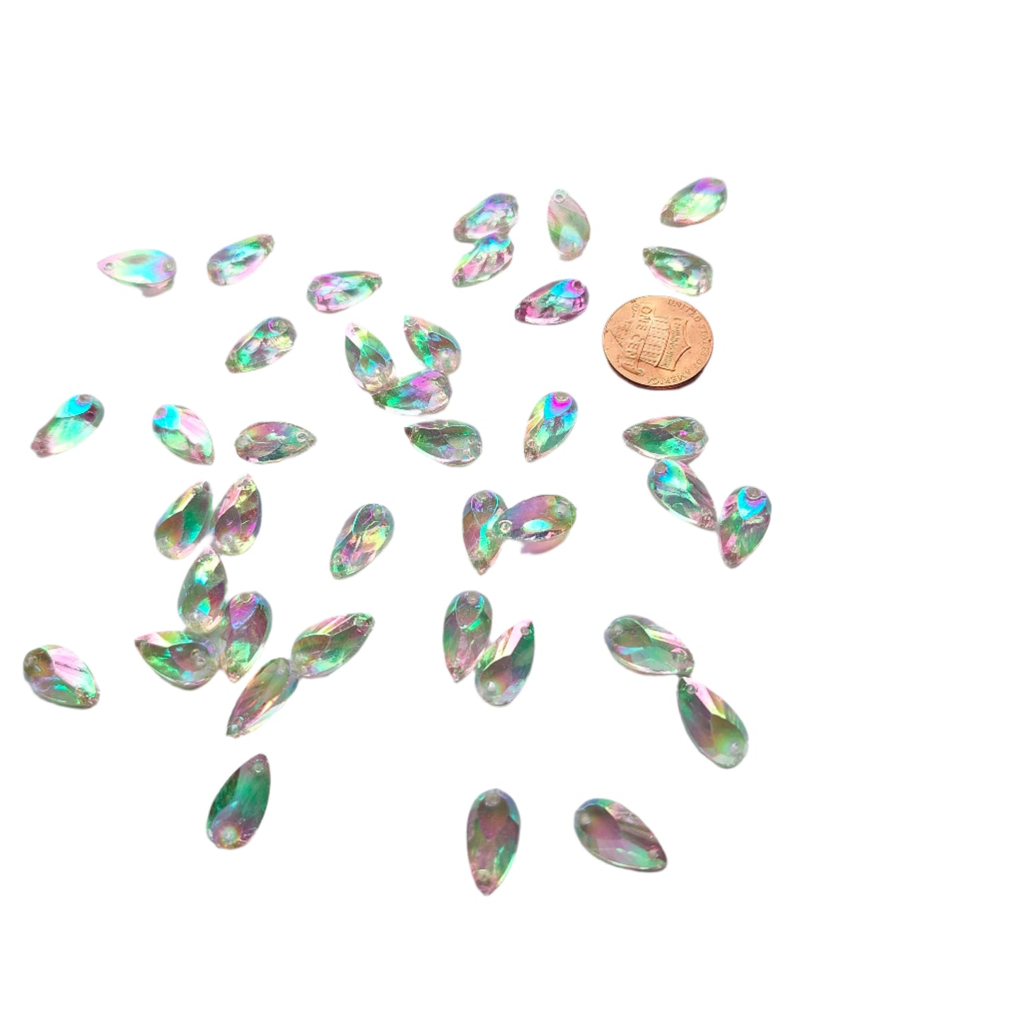 Crystal AB teardrop cabochons shown in a group, including one flipped to display the sew-on back, with a penny for scale.