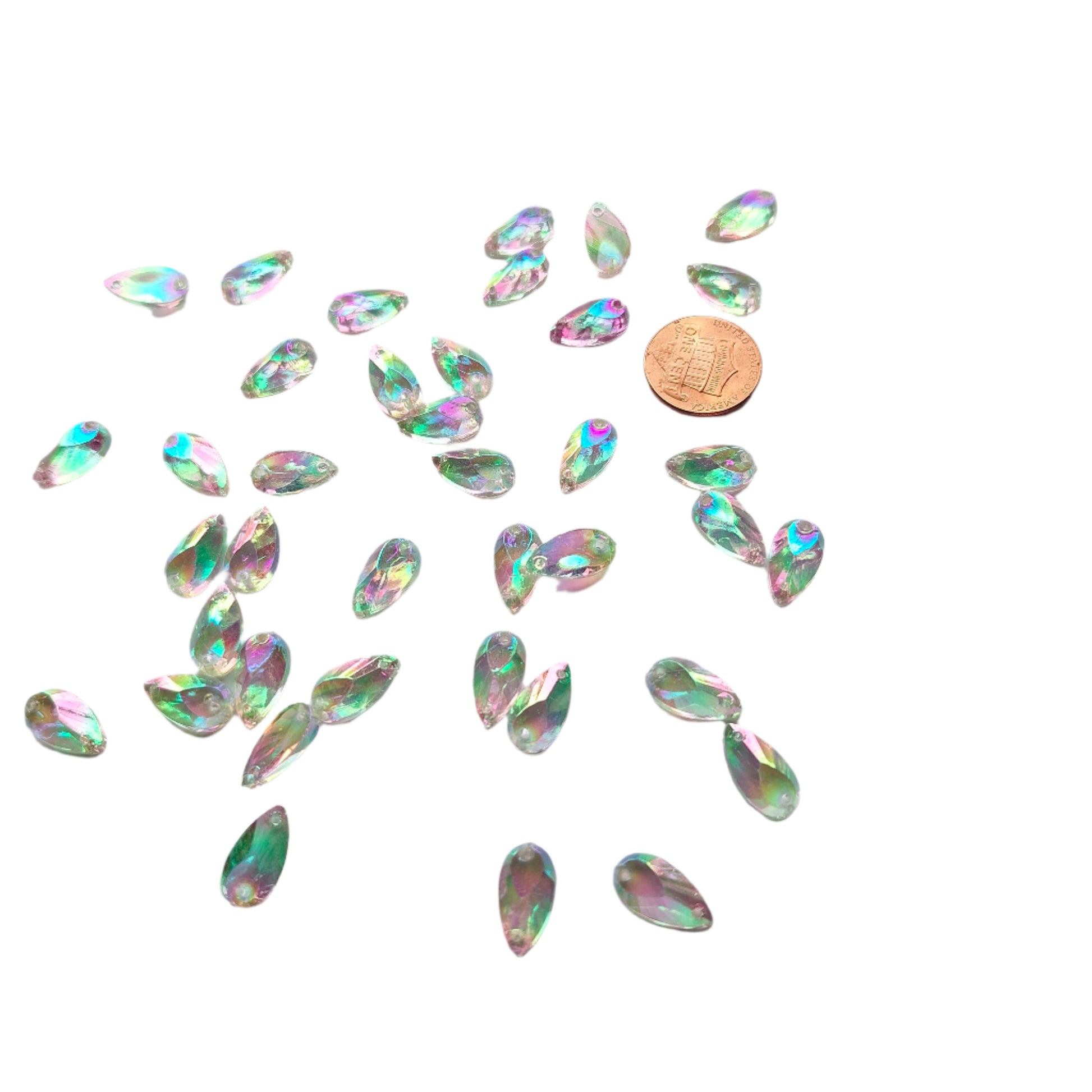 Crystal AB teardrop cabochons shown in a group, including one flipped to display the sew-on back, with a penny for scale.