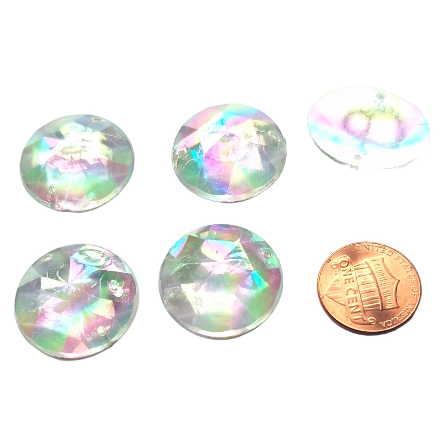 Crystal AB round faceted plastic cabochons arranged in a group of five, with one flipped to show the two-hole sew-on back; penny included for scale.