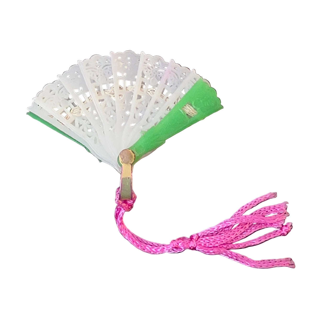 Vintage miniature green plastic folding fan with decorative textured white center panels and bright pink silk tassel.