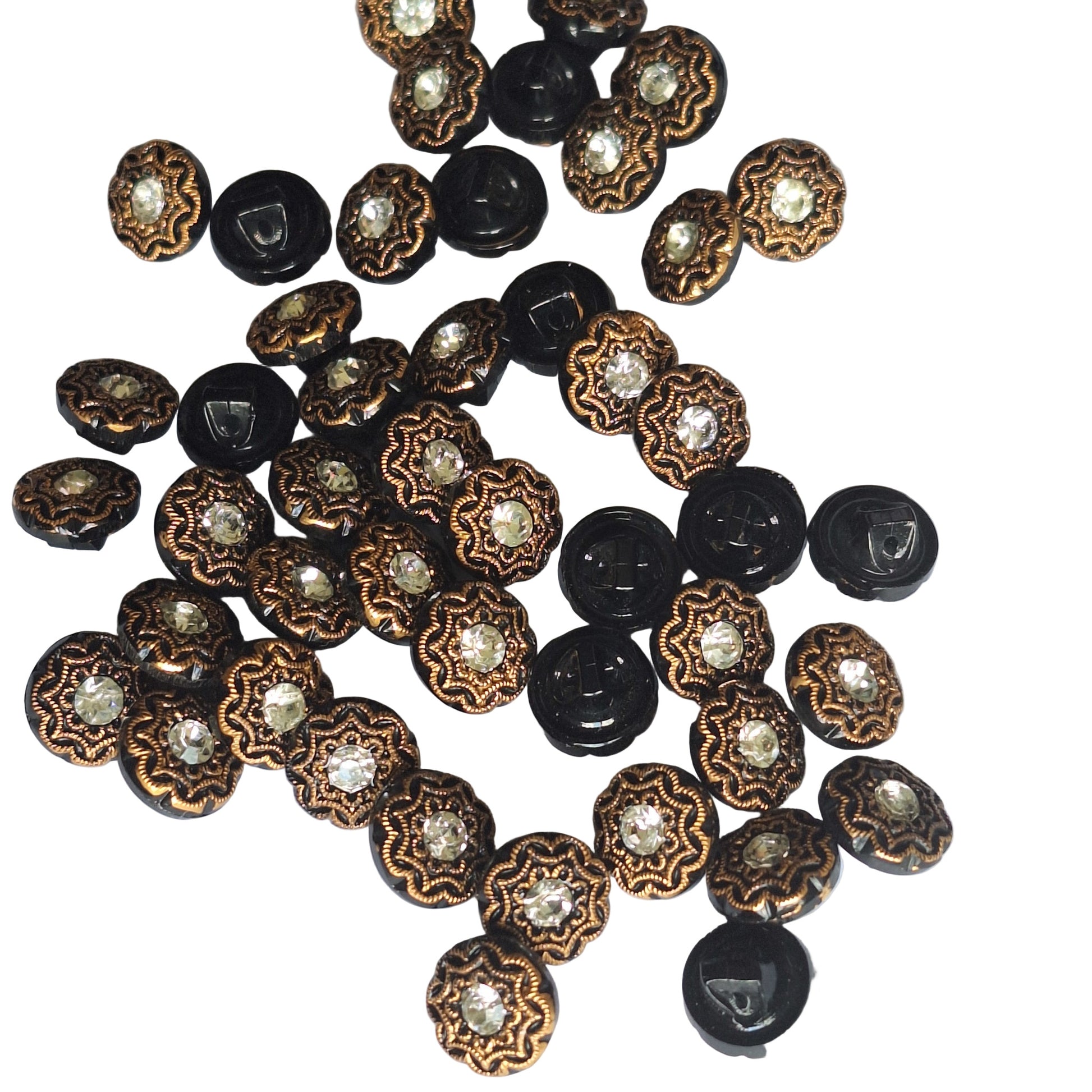 Scattered  black and gold rhinestone glass buttons on a white background