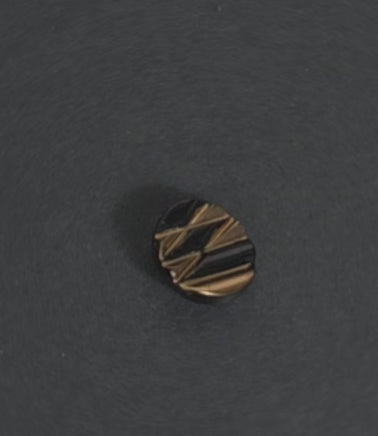 Video of textured glass button with copper and black geometric pattern.