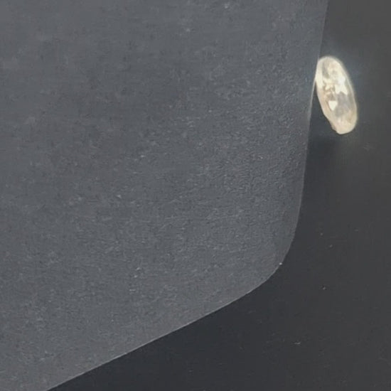 Mirrored glass button with concave form and faceted rim, two-hole, 14mm, , shown in video with light movement to display the mirrored finish.