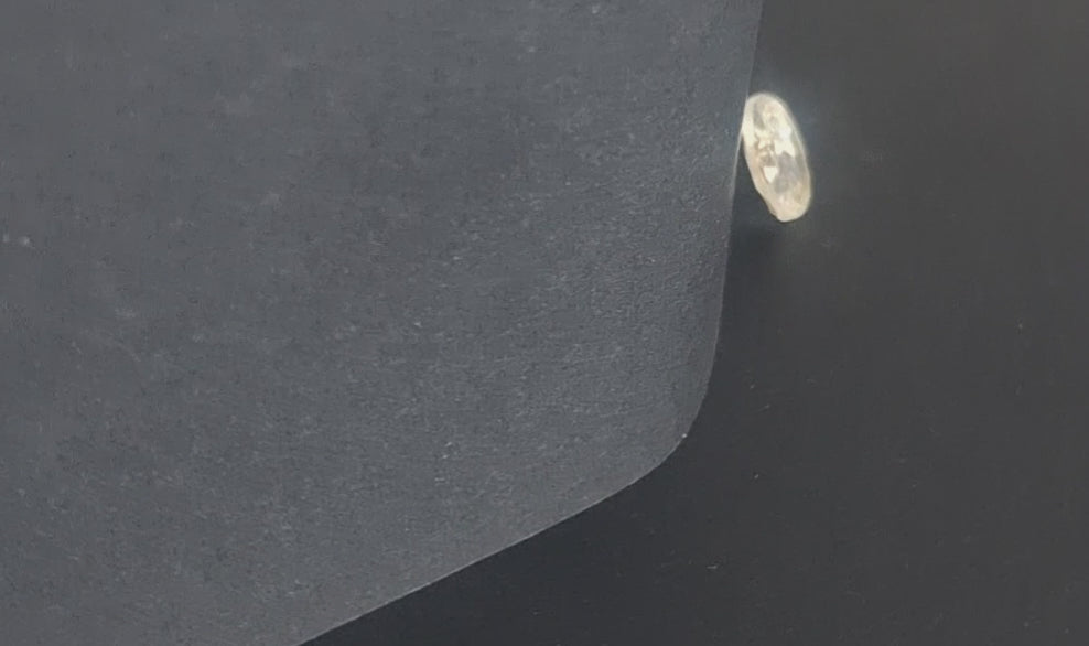 Mirrored glass button with concave form and faceted rim, two-hole, 14mm, , shown in video with light movement to display the mirrored finish.