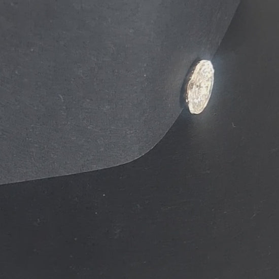 Mirrored glass button with concave form and faceted swirl pattern, two-hole, 14mm, shown in video with light movement to display the mirrored finish.